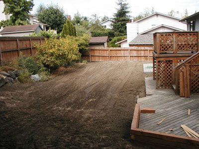 Kirkland Landscaping Services transformed a backyard with dirt into a beautiful outdoor space featuring a wooden deck.