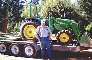 A man standing next to a tractor on the Issaquah Plateau.