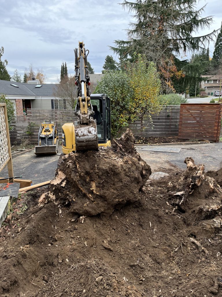 An excavator is removing a pile of dirt.
