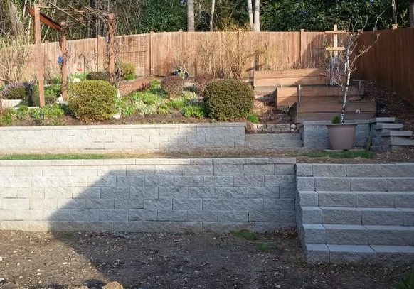 A backyard with a retaining wall and steps.